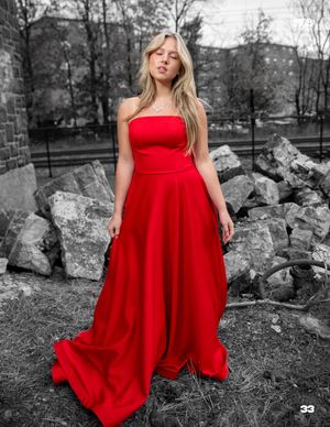 Dramatic red gown photo against black and white rocky background.