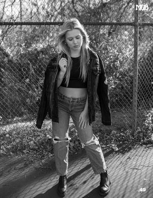 Casual streetwear fashion photo with model in denim jacket and distressed jeans.