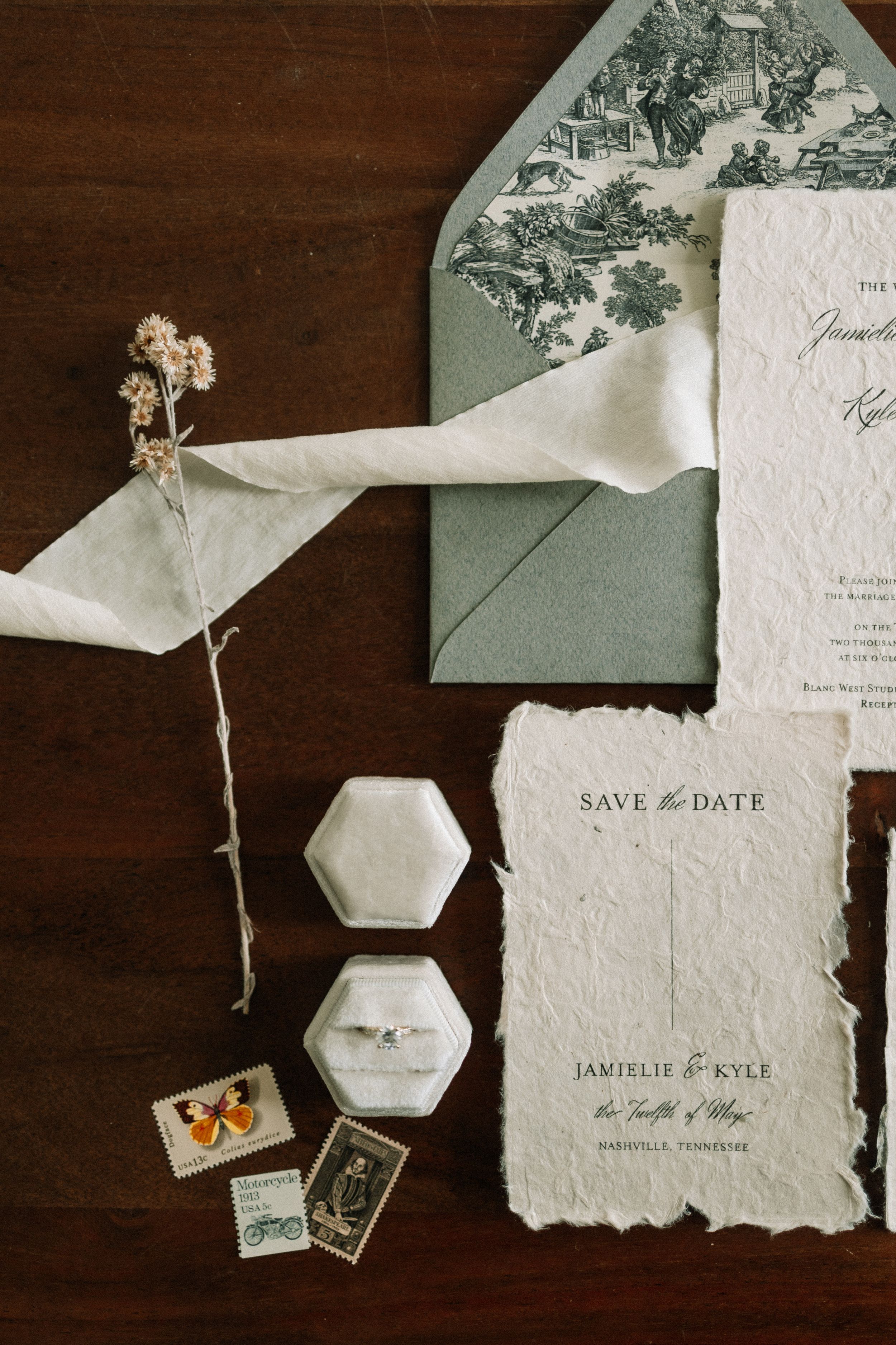 Wedding invitation suite with sage green envelope, dried flowers, and deckled edge paper.
