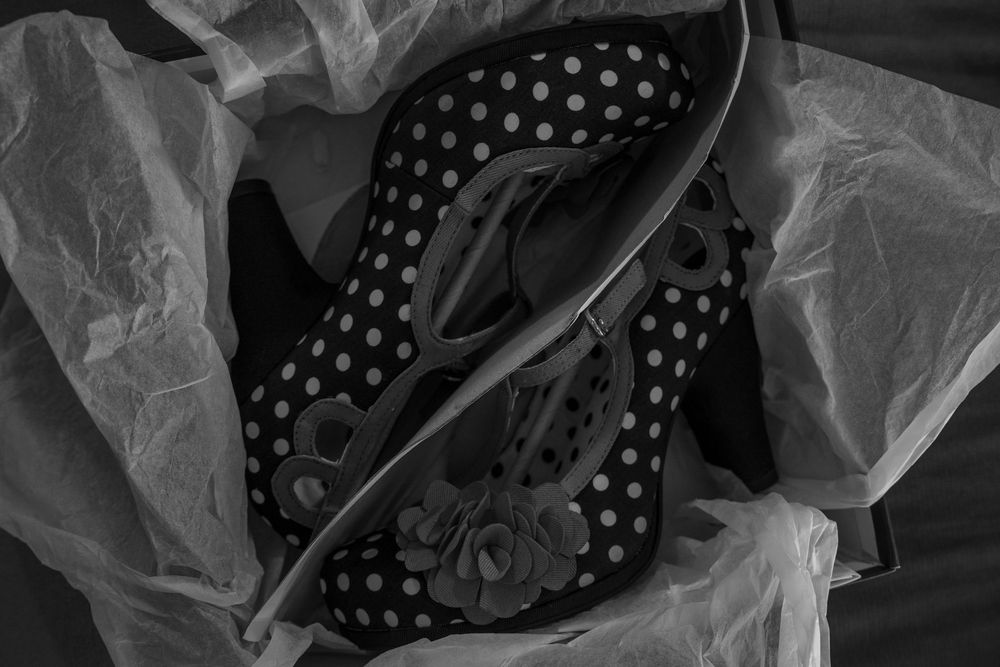 Black and white polka dot designer high heel shoes wrapped in delicate tissue paper.