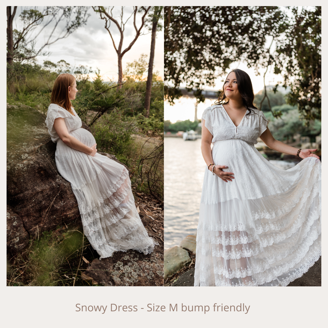White lace Snowy Dress size M bump friendly, elegant tiered maxi gown worn by pregnant women outdoors.