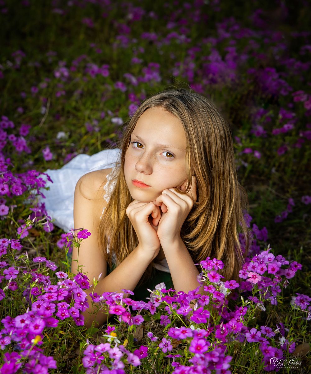 A dreamy portrait in a field of purple flowers with soft natural lighting.