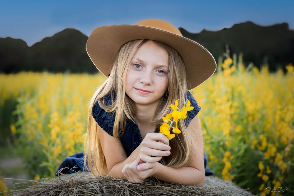 Candid shots in a sunflower field featuring a brown hat and natural lighting.