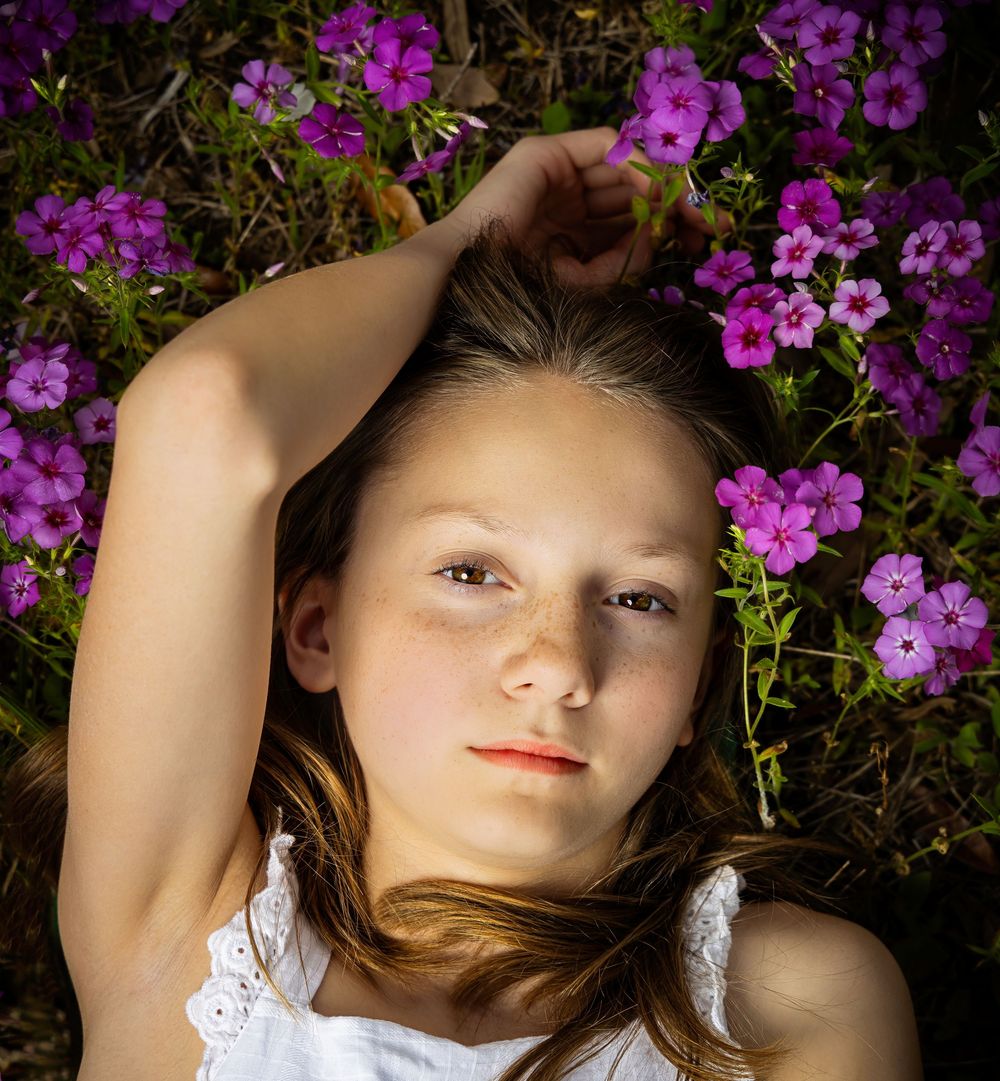 Artistic portrait series against a backdrop of bright purple flowers.