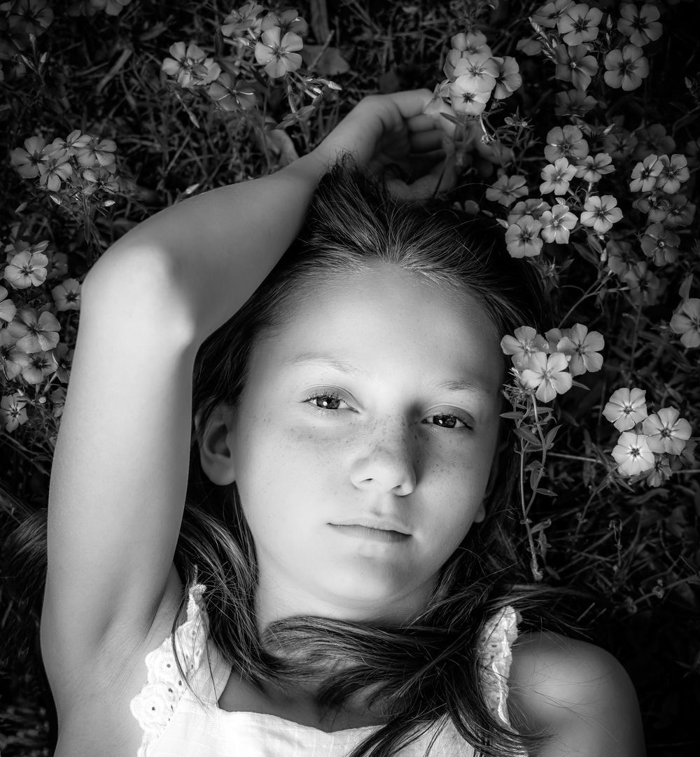 Black and white portrait series with delicate flowers creating a dreamy atmosphere.