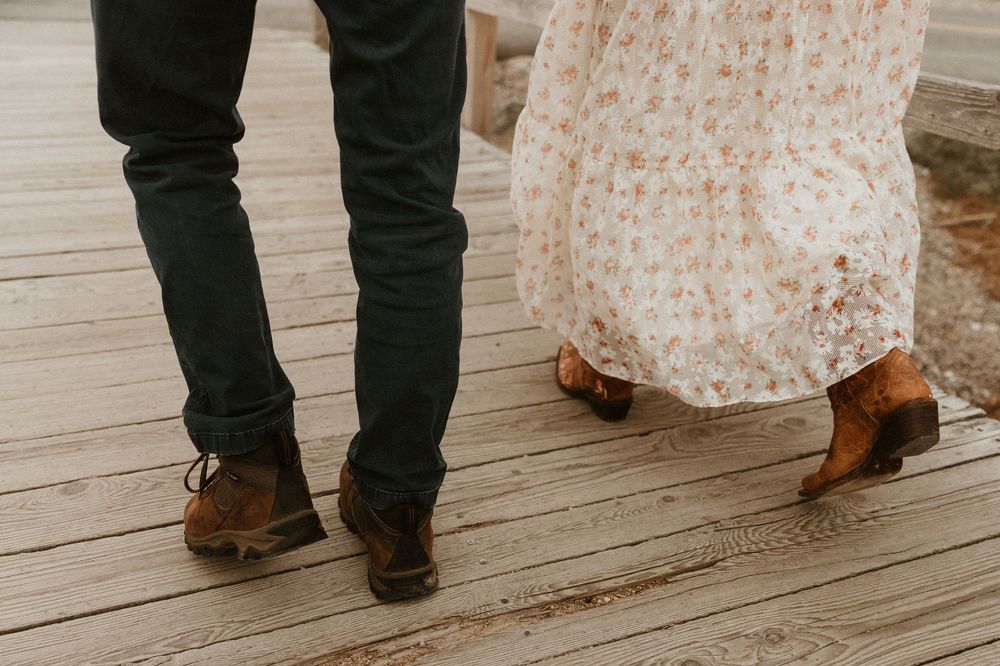 Close-up of feet walking on wooden boardwalk steps.