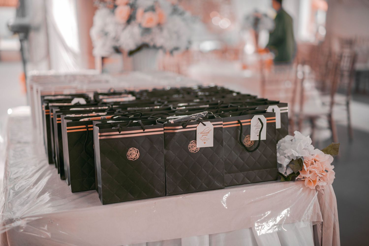 Wedding favors or gift boxes arranged on table with floral decorations.