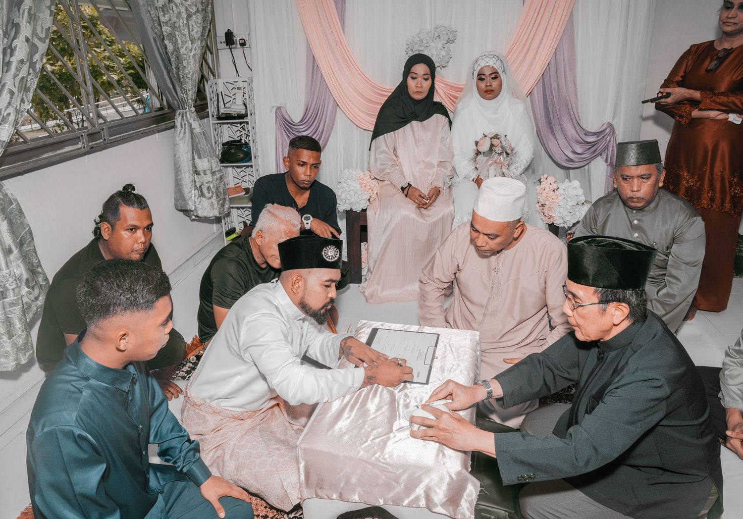Traditional wedding ceremony with guests gathered around signing documents.