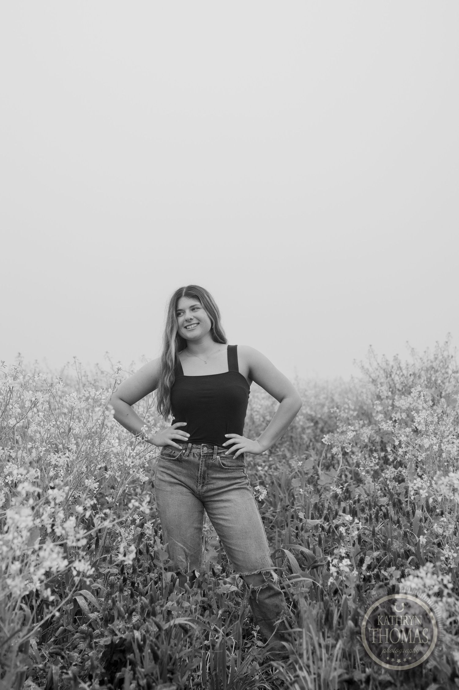 Black and white portrait in a meadow featuring casual style and natural composition.