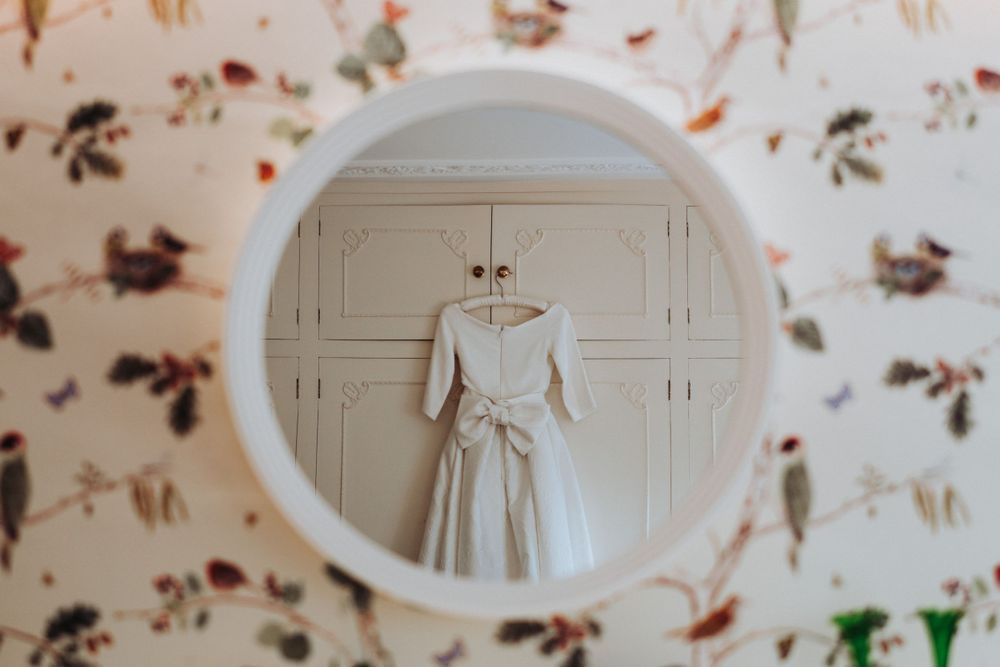 Intricate wedding dress details photographed in a Yorkshire bridal suite, creatively captured through a mirror
