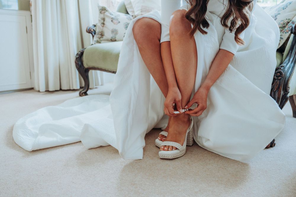 Candid photography of bride tying wedding shoes in North Yorkshire