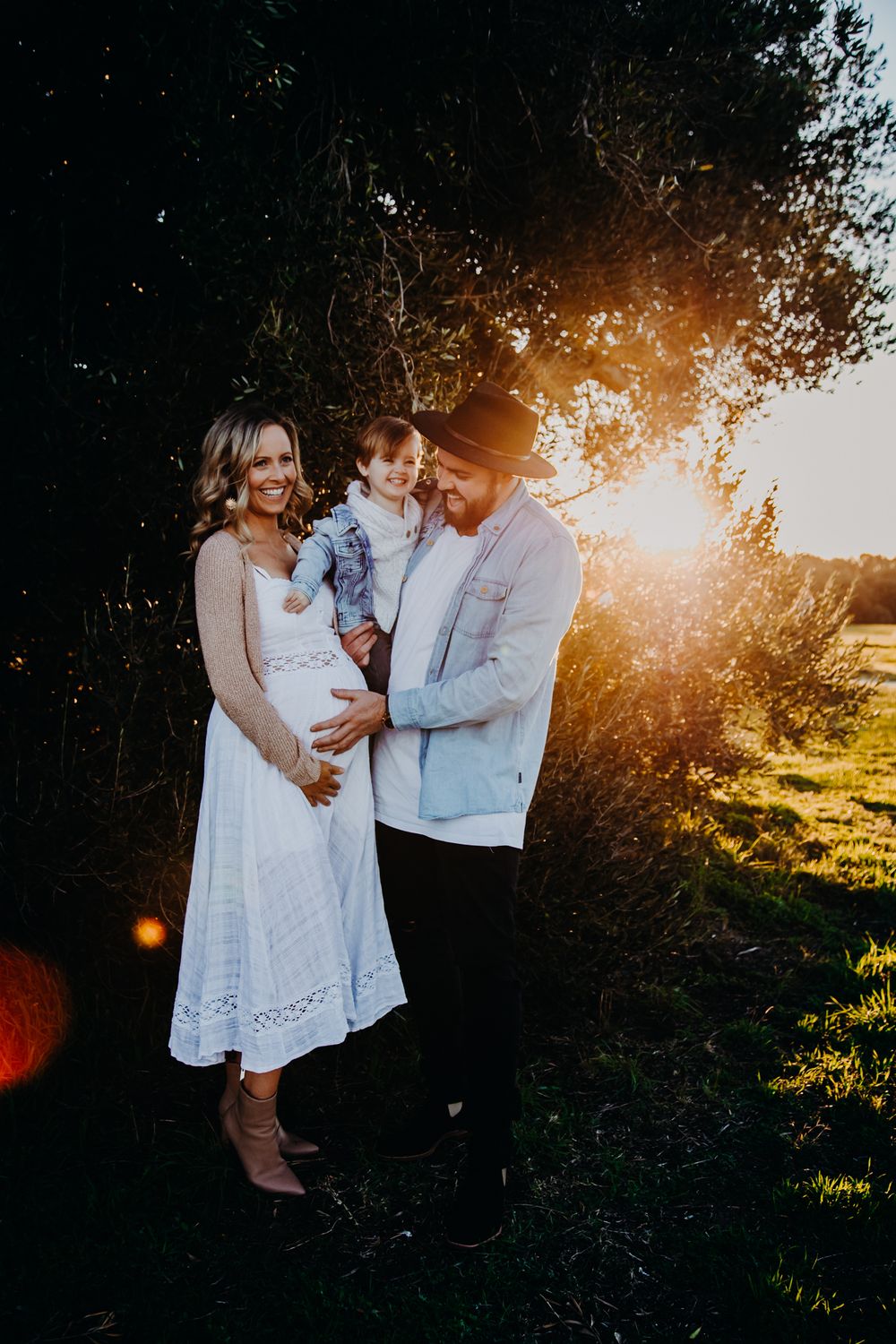 Romantic couple sharing intimate moment at sunset in a natural outdoor setting.