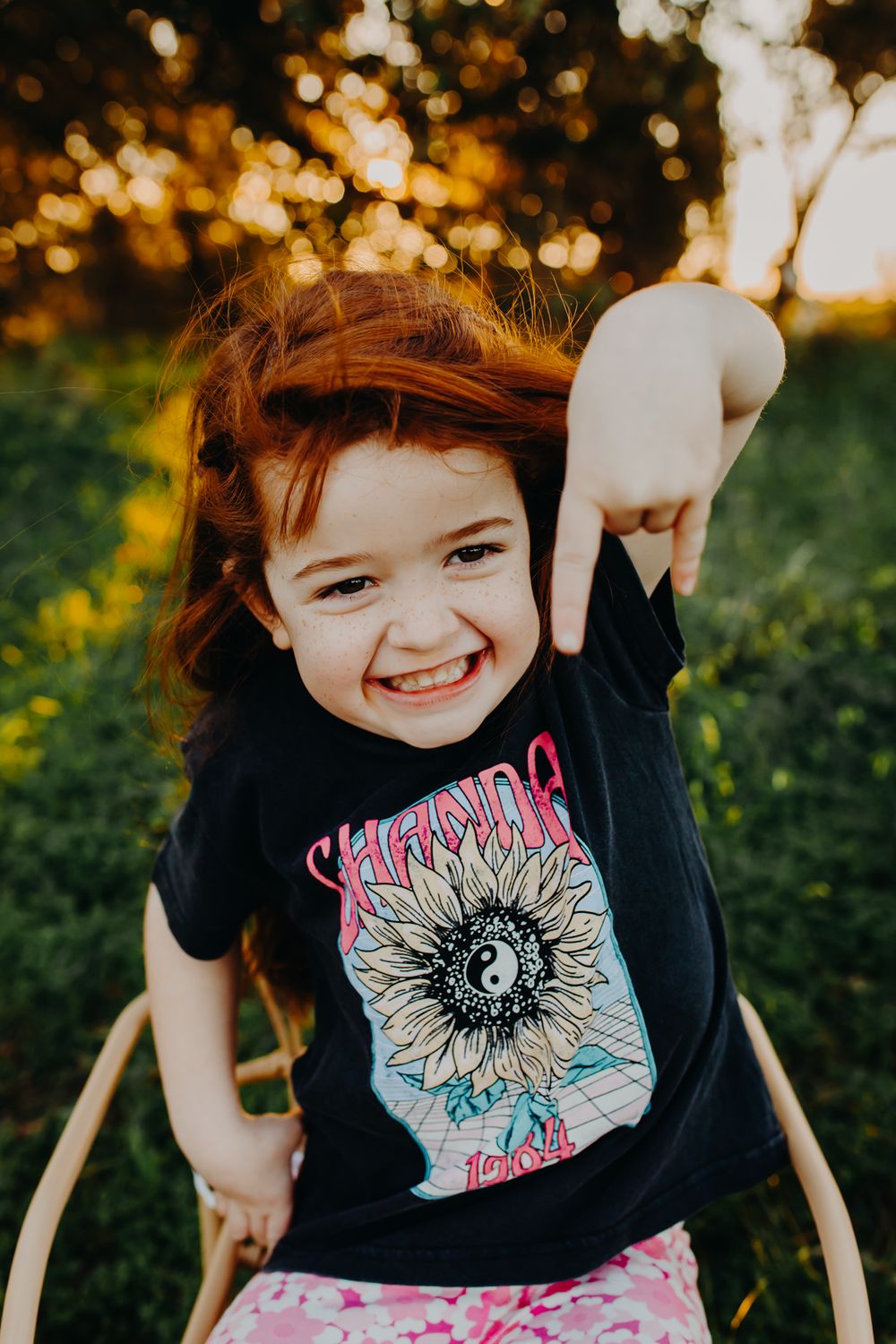 A playful expression in a black t-shirt with a sunny bokeh background.