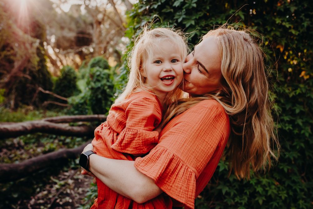 A joyful embrace in matching coral outfits during golden hour.