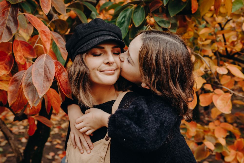 Sweet autumn moment with falling orange leaves in background.