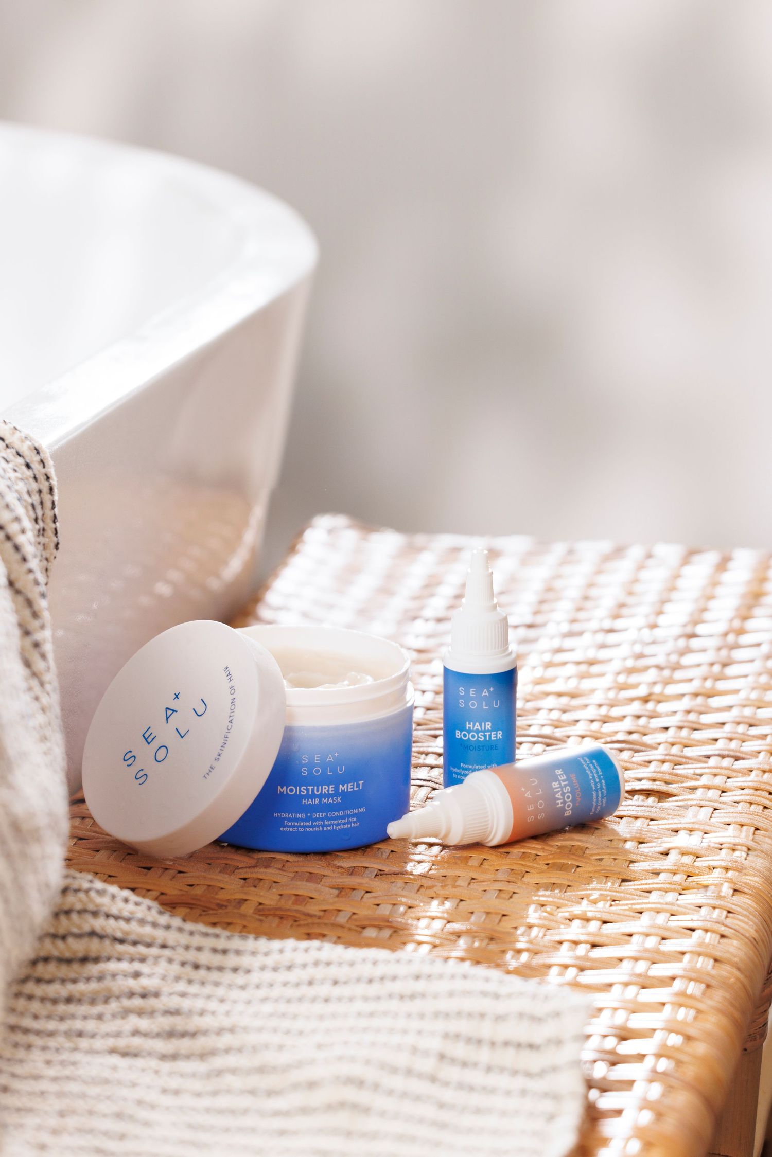 Sea Solu skincare products arranged on woven surface with soft natural lighting.