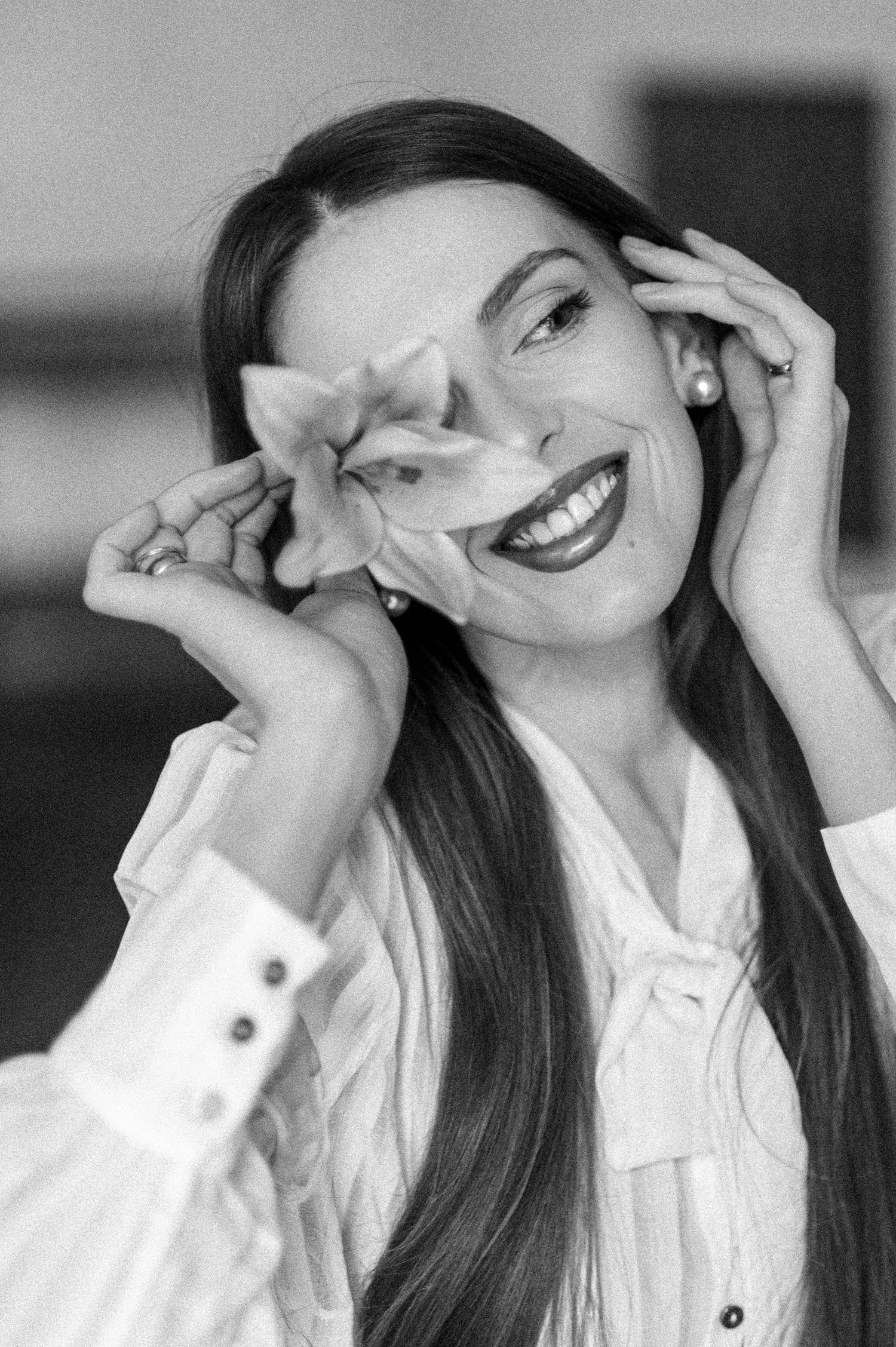 Candid black and white sequence showing joyful laughter in a white button-down shirt.