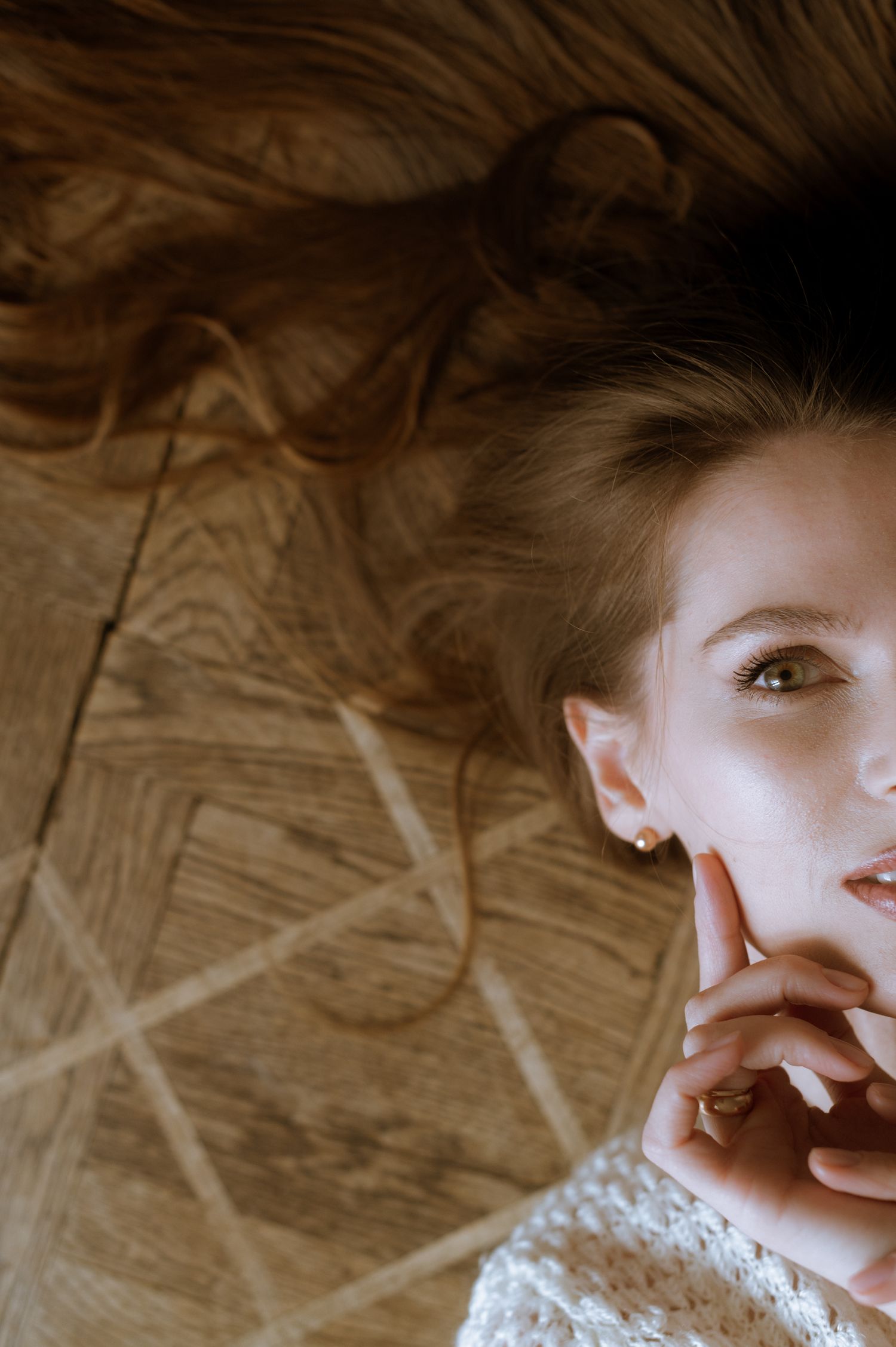 Intimate portrait with dramatic shadows and natural window light creating a moody atmosphere.