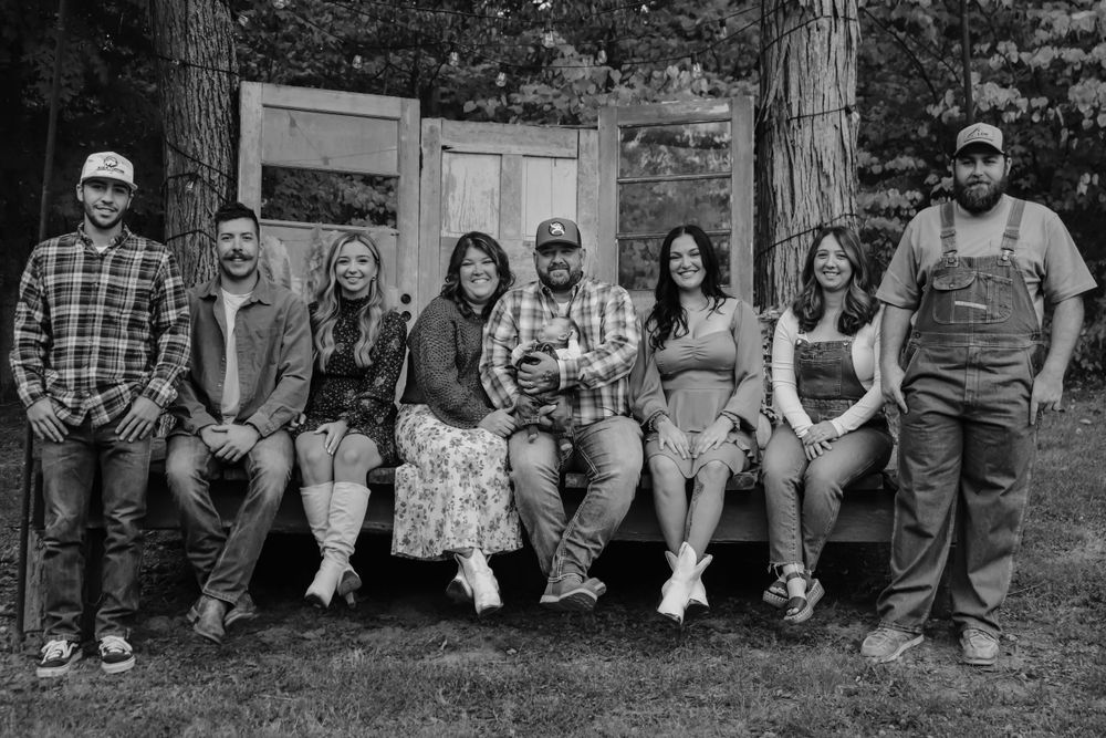People sitting in a row on wooden steps for a casual outdoor group photo.