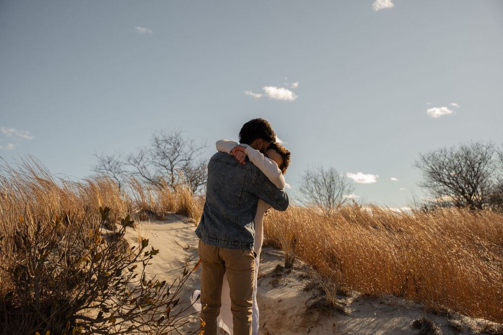 A couple hugs on Wingaersheek Beach, MA. Captured by Kaci, wedding photographer based out of the New York City Metropolitan area.