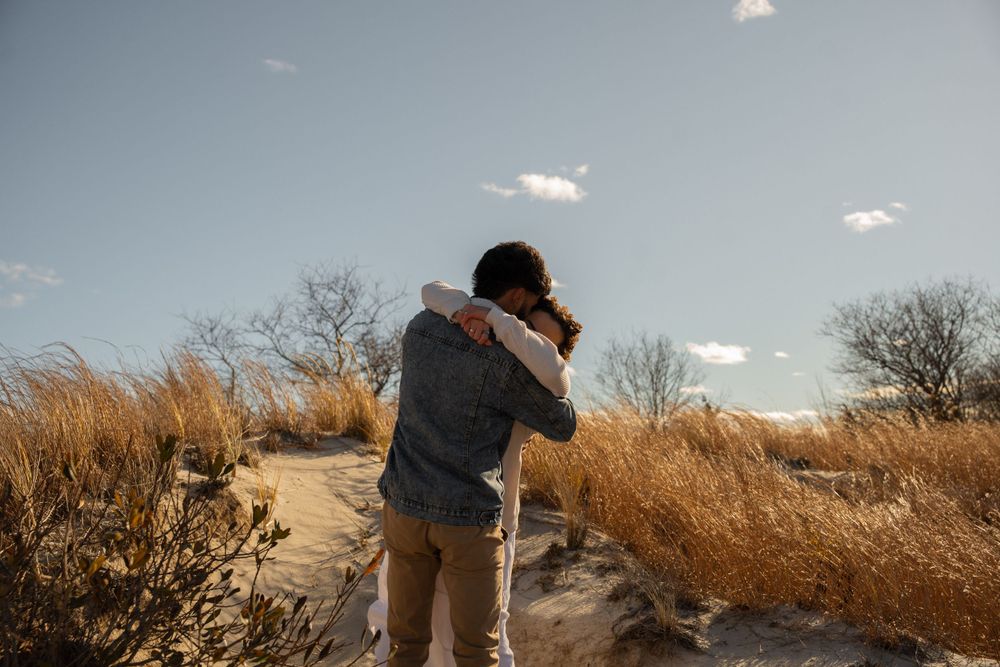 A couple embraces on Wingaersheek Beach, MA. Captured by Kaci, wedding photographer based out of the New York City Metropolitan area.