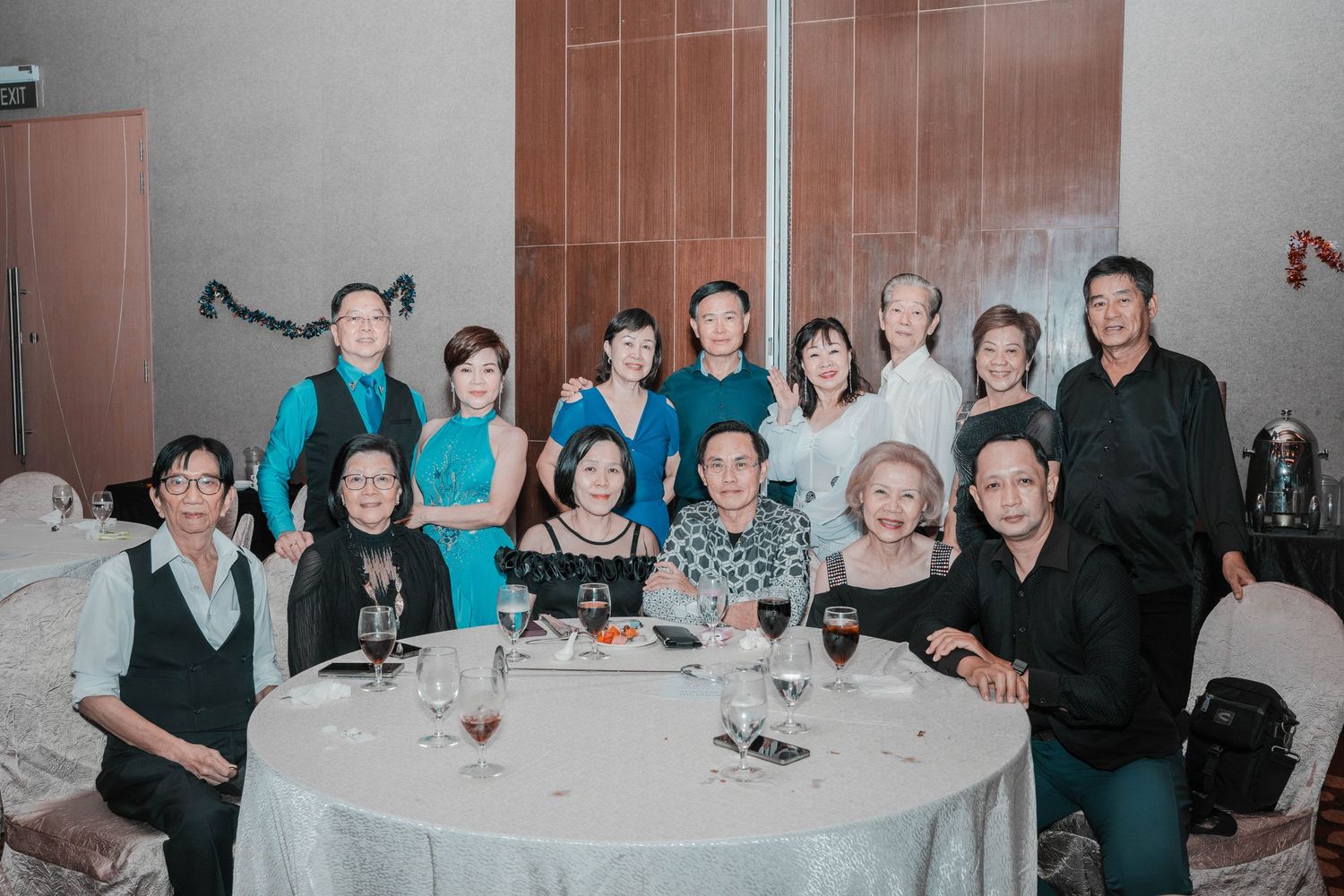Large group posed around an elegant dining table at a formal evening gathering.