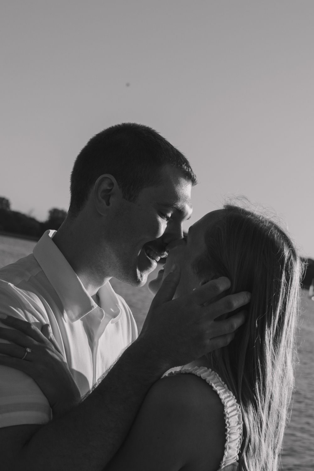 Intimate black and white portrait of couple by waterfront.