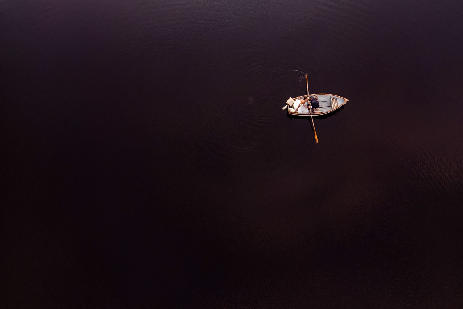 Lake District Wedding Photography: Bride and groom kiss in a boat on Knipe Tarn at Gilpin hotel - Aerial Photo