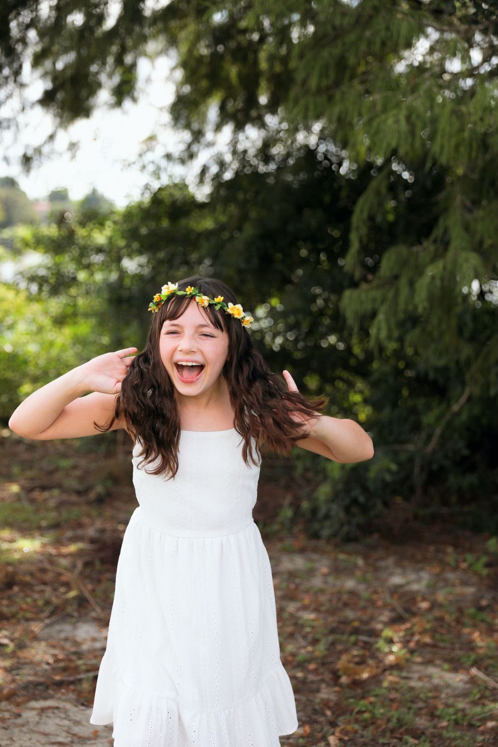 Playful outdoor shoot in a white dress with natural scenery.