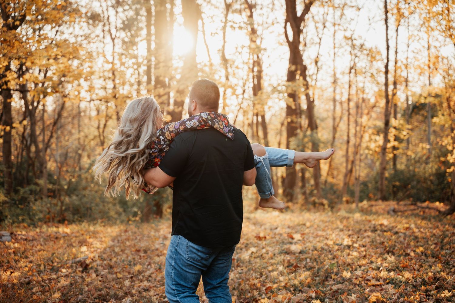 A playful piggyback ride moment captured in a sunlit autumn forest.