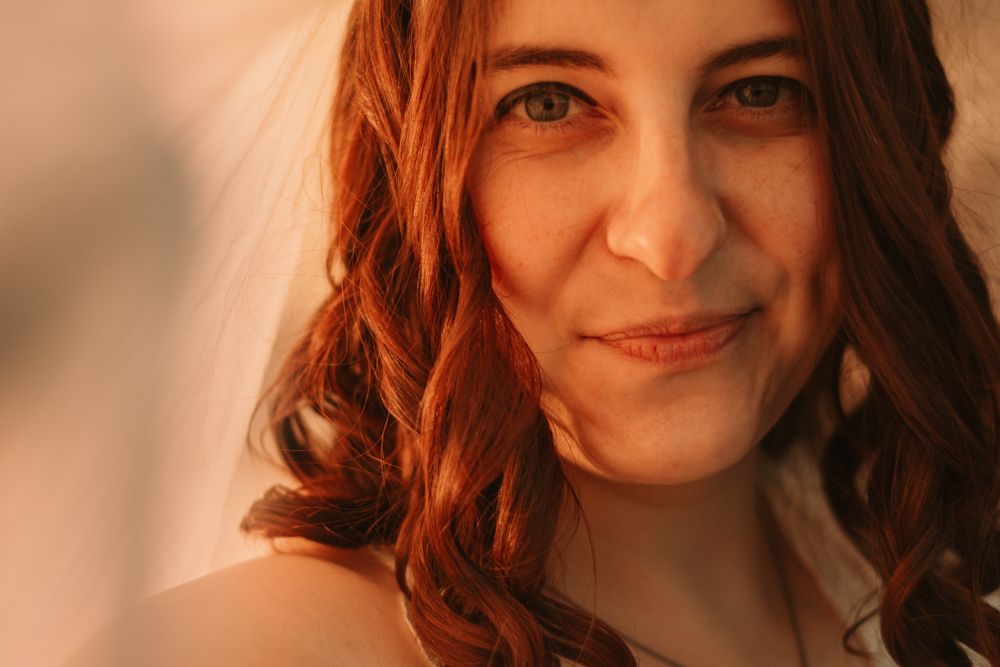 Close-up warm-toned portrait with auburn hair in natural lighting.