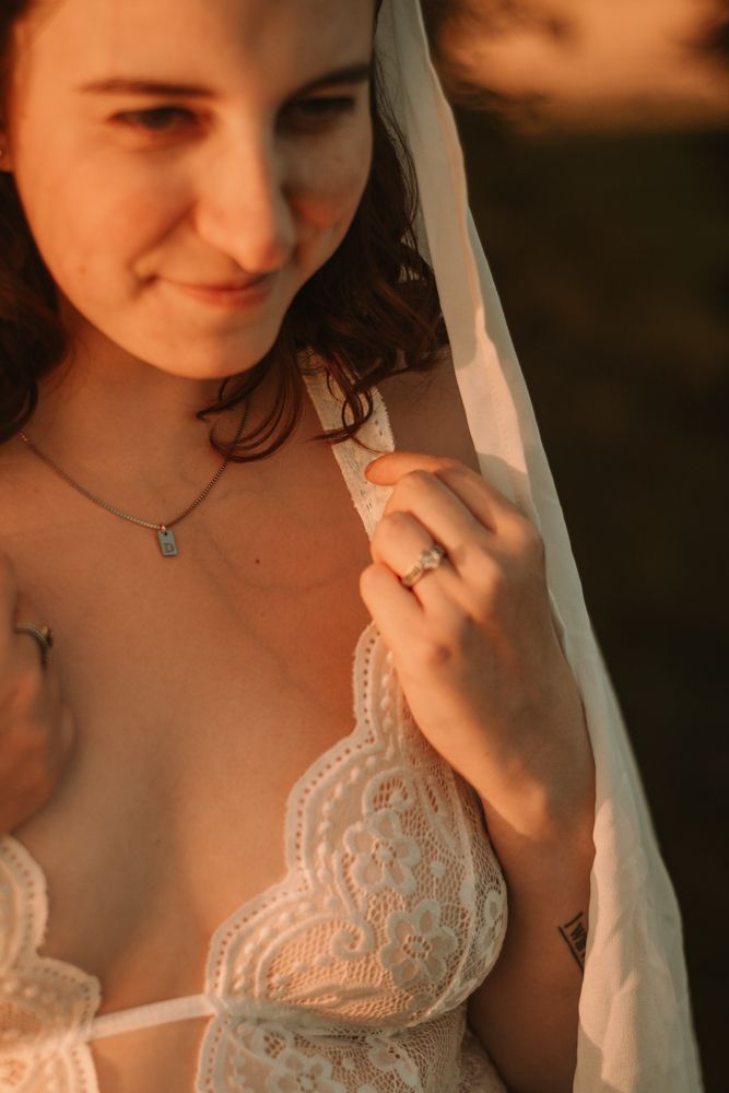 A soft portrait showcasing delicate lace details and a turquoise necklace in warm sunset lighting.