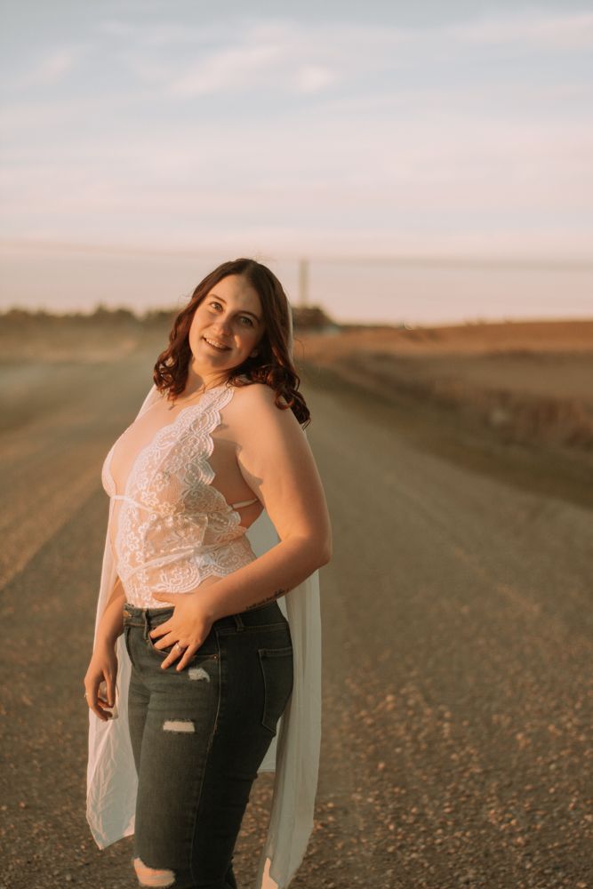 Casual portrait against rural landscape featuring lace details and natural evening light.