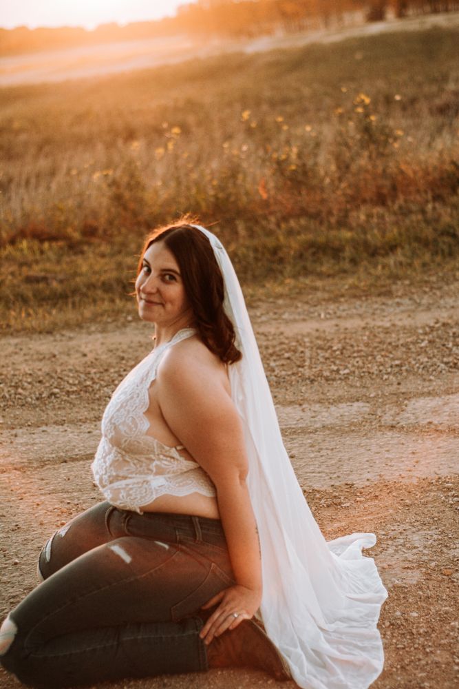 Sunset portrait in field featuring lace details and flowing white fabric.