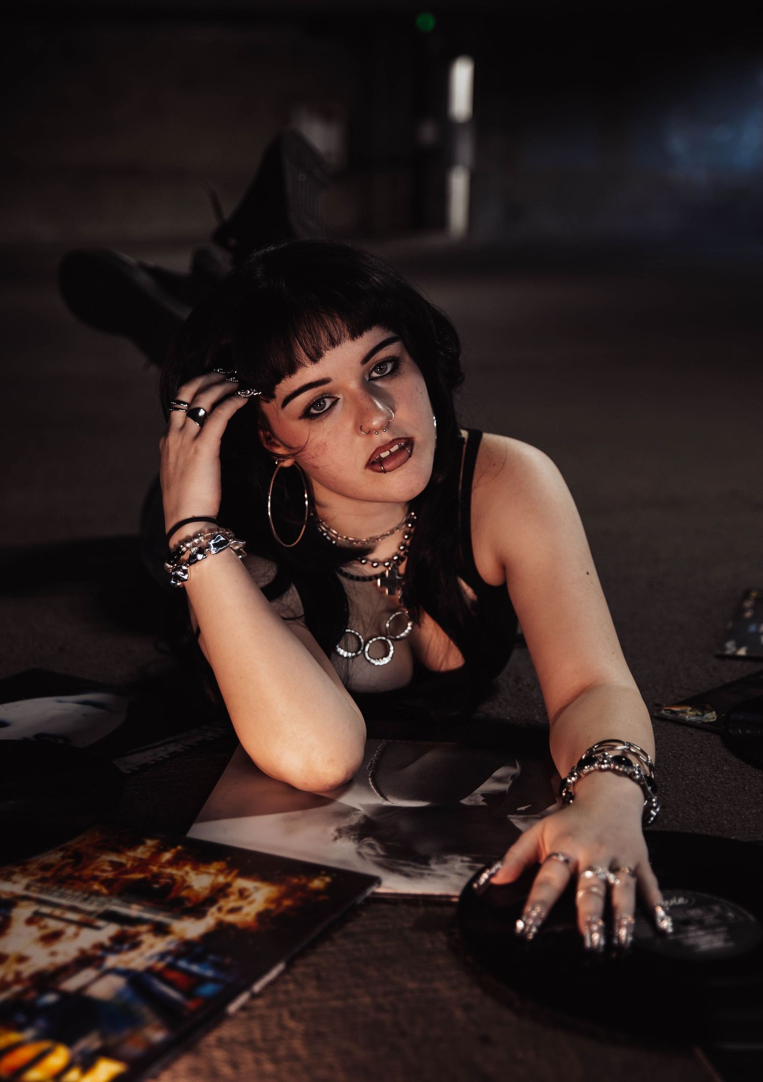 Girl lays on vinyl albums for moody, cinematic, urban, portrait, senior photos in Denver, Colorado outside, urban, and nature photos