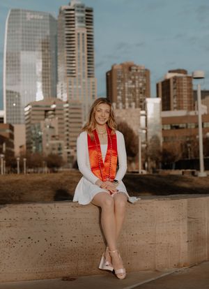 Girl sits down and poses for graduation photos, cinematic photos, and portraits in Denver, Colorado outside and in nature photo