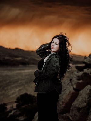Woman poses in front of dramatic, cinematic sky for portrait and modeling photos in Fort Collins, Colorado