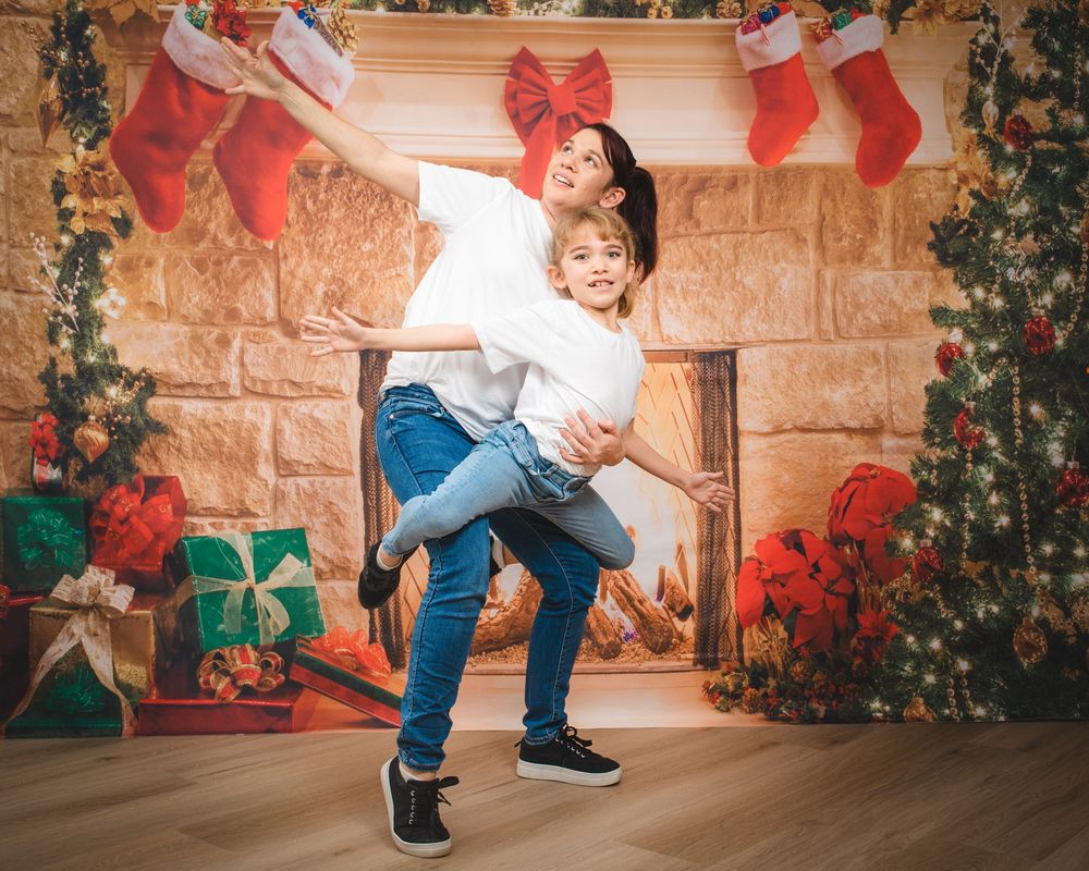 Awkward family photo of mum and daughter wearing matching clothes. child is being held by mum to look like she's flying.