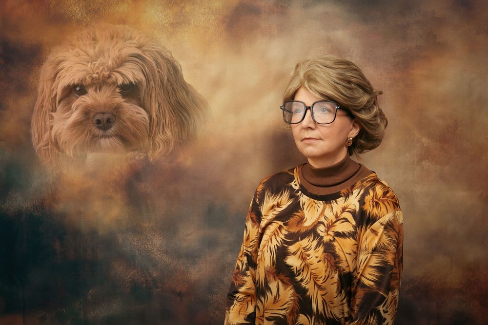 Awkward portrait of a lady in a brown retro top, big glasses, blonde 70's hair, staring blankly, with a floating pet head in the corner