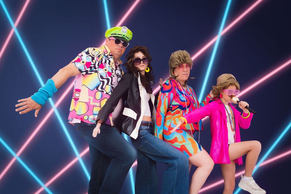Awkward photo of a family of four wearing hideous 80's clothes against a neon laser backdrop.
