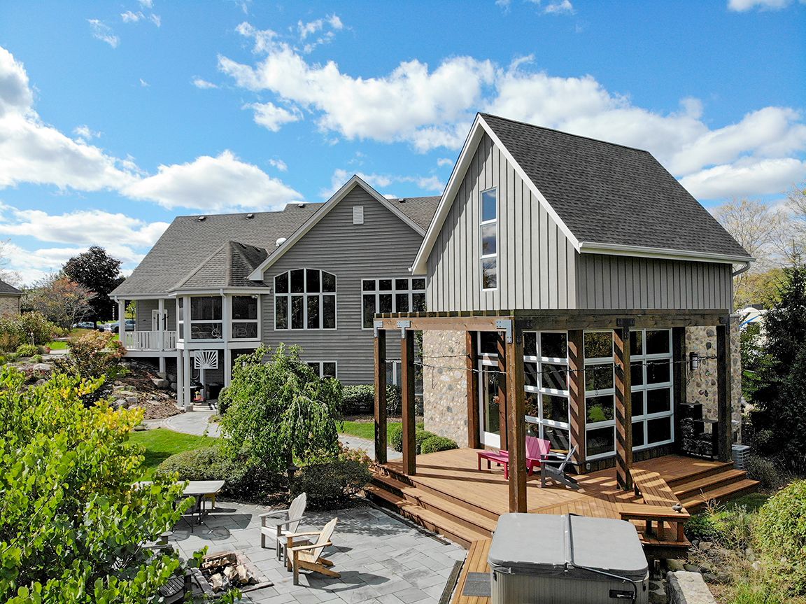 Aerial drone photo of a gray two-story home with gabled roof, Milwaukee area