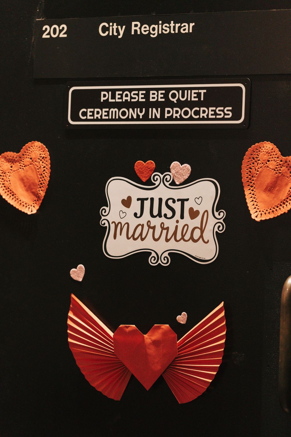 City Registrar office door decorated with Just Married sign, origami heart, and Please Be Quiet Ceremony In Progress notice.