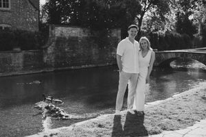 Couple embracing after a surprise proposal in Bourton-on-the-Water.