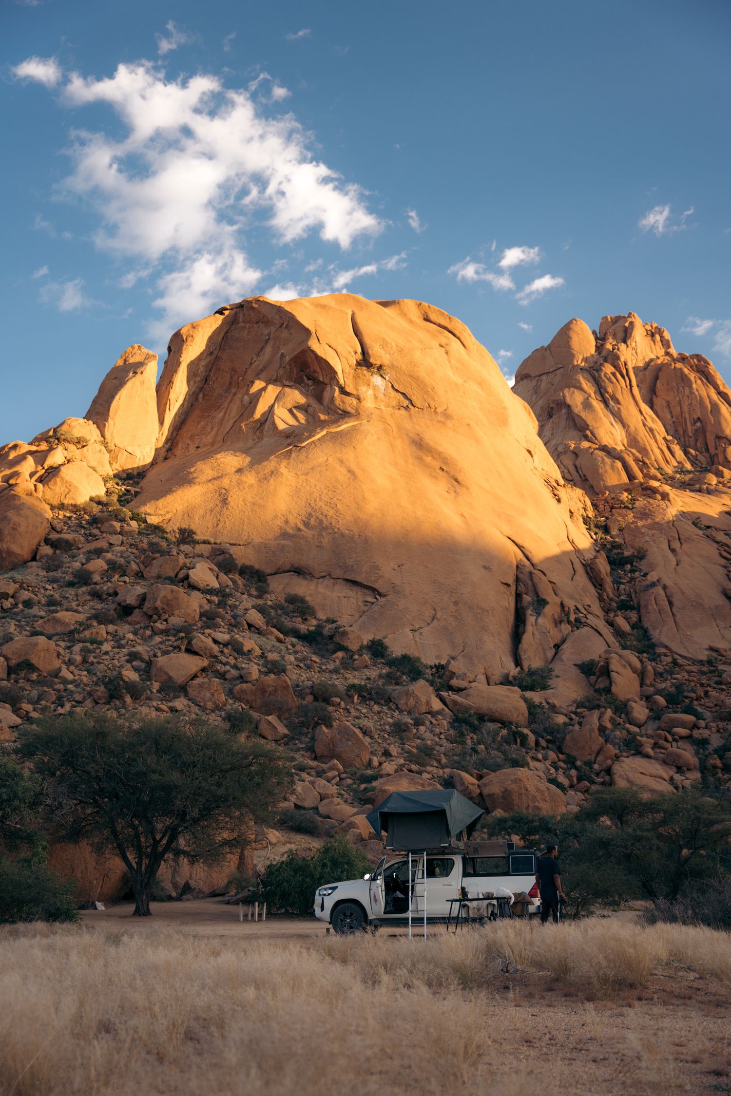 4x4 avec tente de toit au pied de smontagne de spitkoppe au coucher du soleil