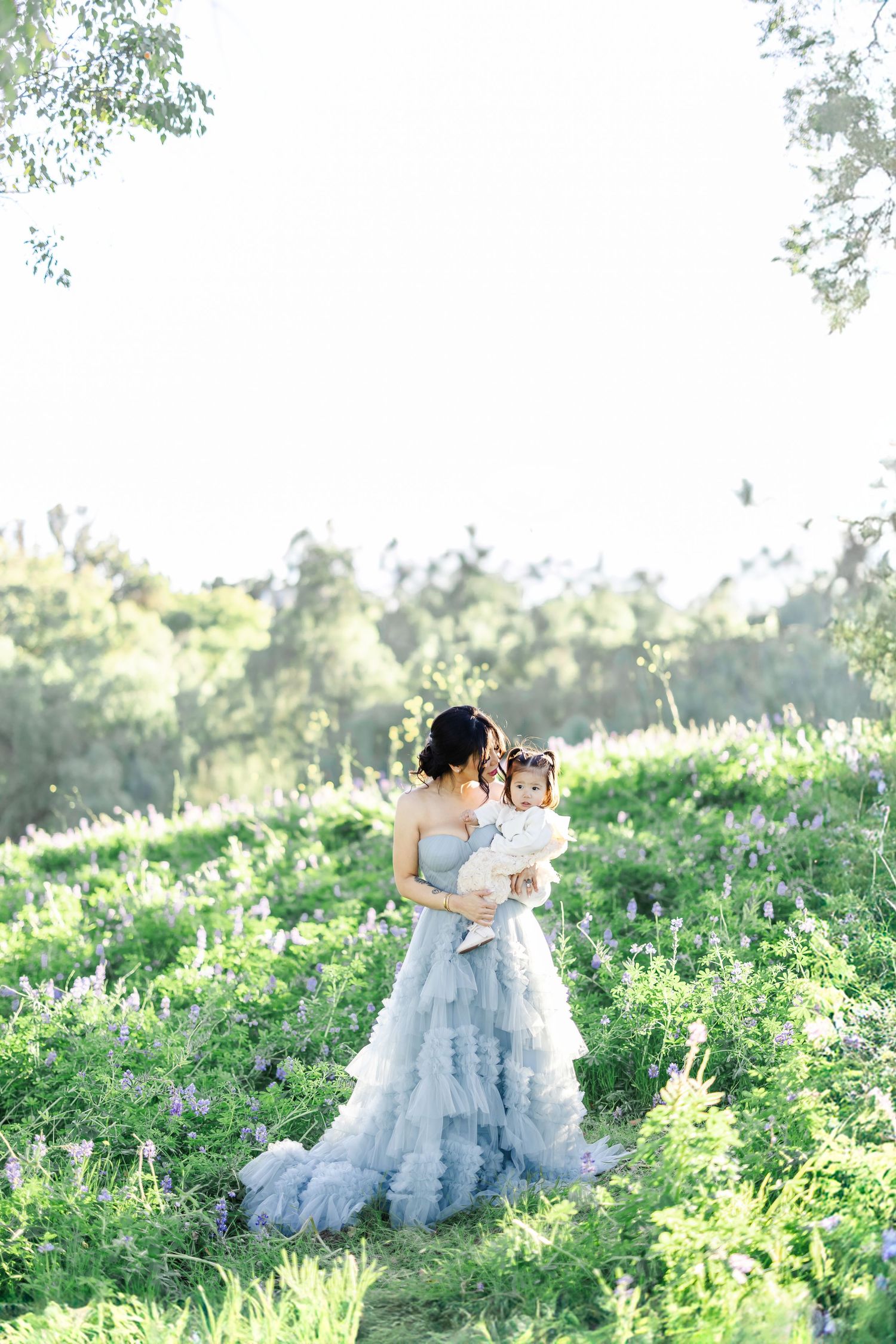 Two women share intimate embraces while sitting outdoors in natural lighting.