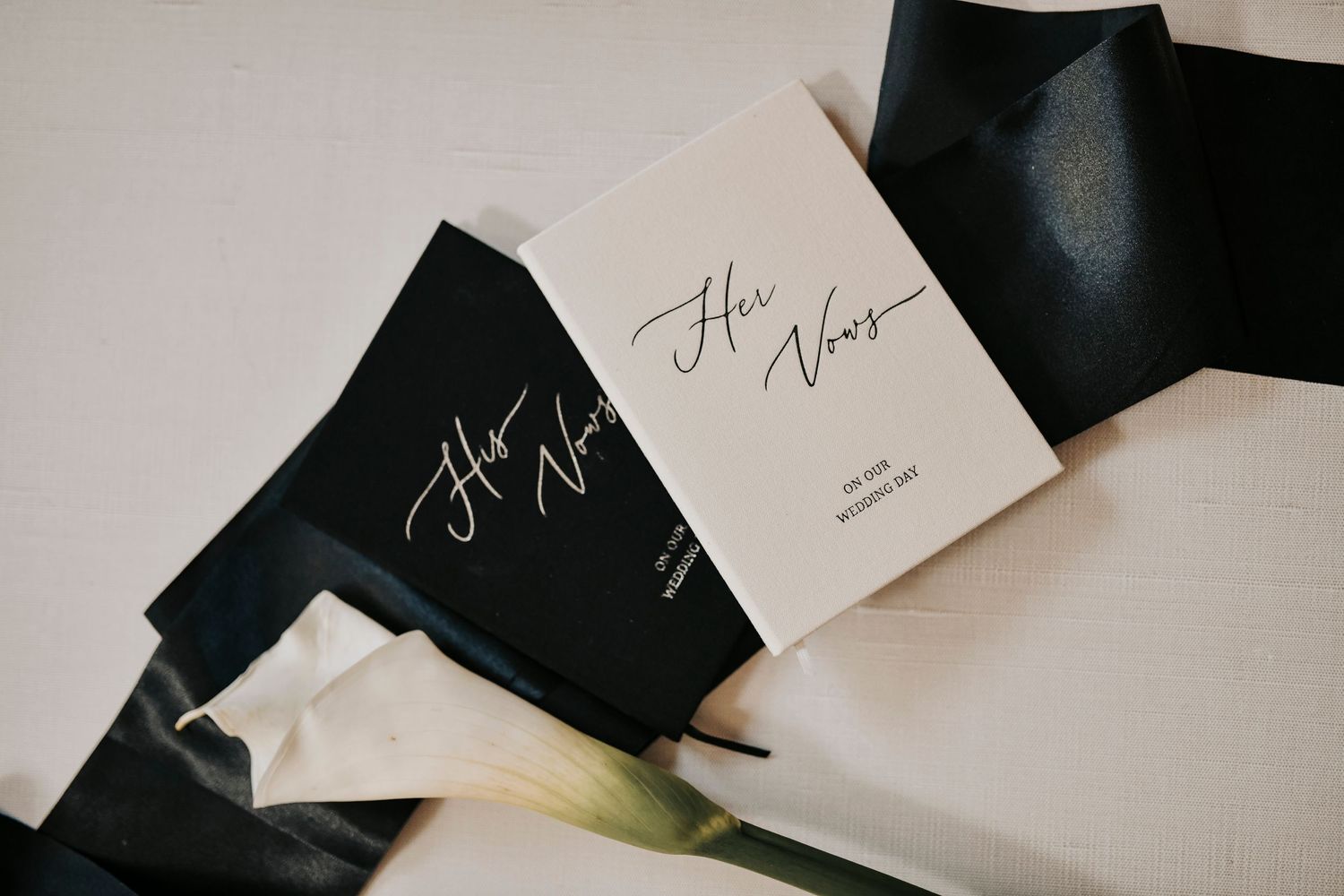 Luxury wedding flat lay featuring black satin ribbon and bridal accessories