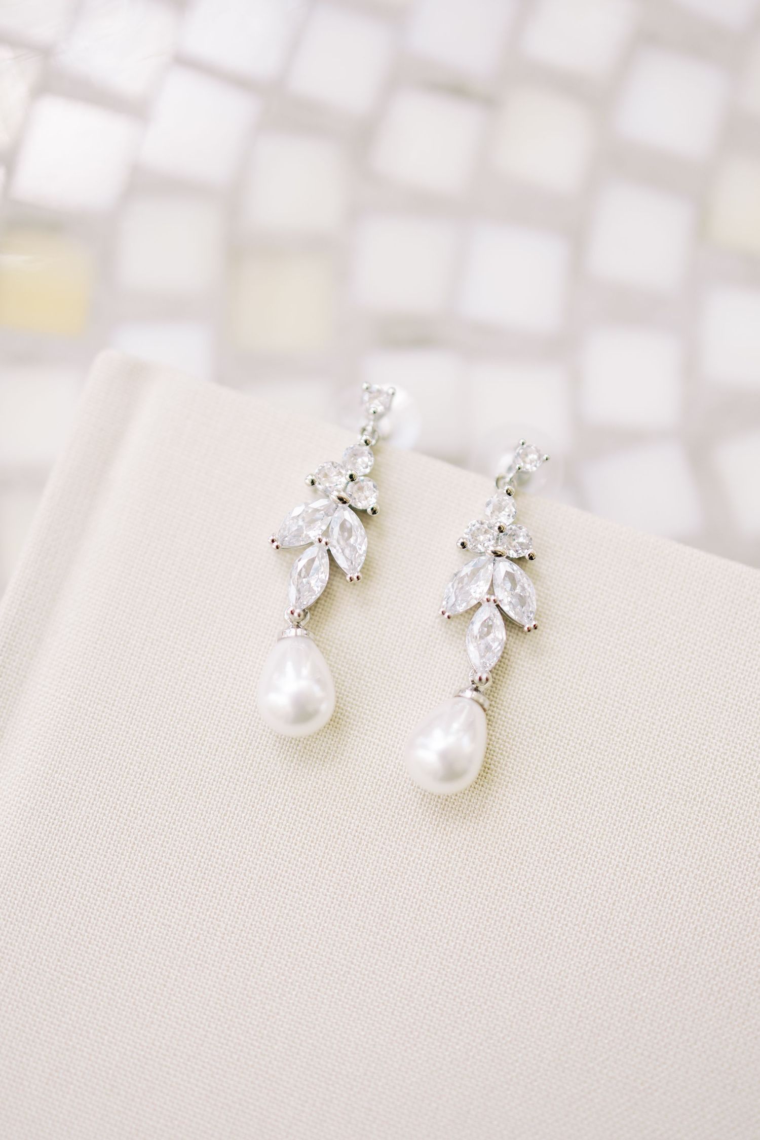 Elegant silver drop earrings featuring marquise crystal leaves and lustrous freshwater pearl drops, perfect for bridal jewelry.