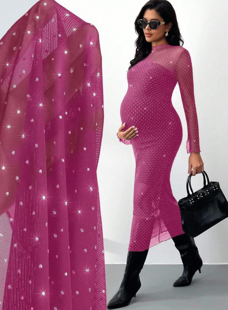Pregnant woman in pink sparkly mesh midi dress with long sleeves, paired with black boots and handbag.