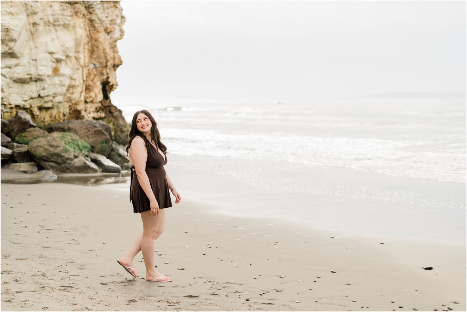 Senior photographer capturing authentic senior photos in Avila Beach during a cloudy morning beach session.