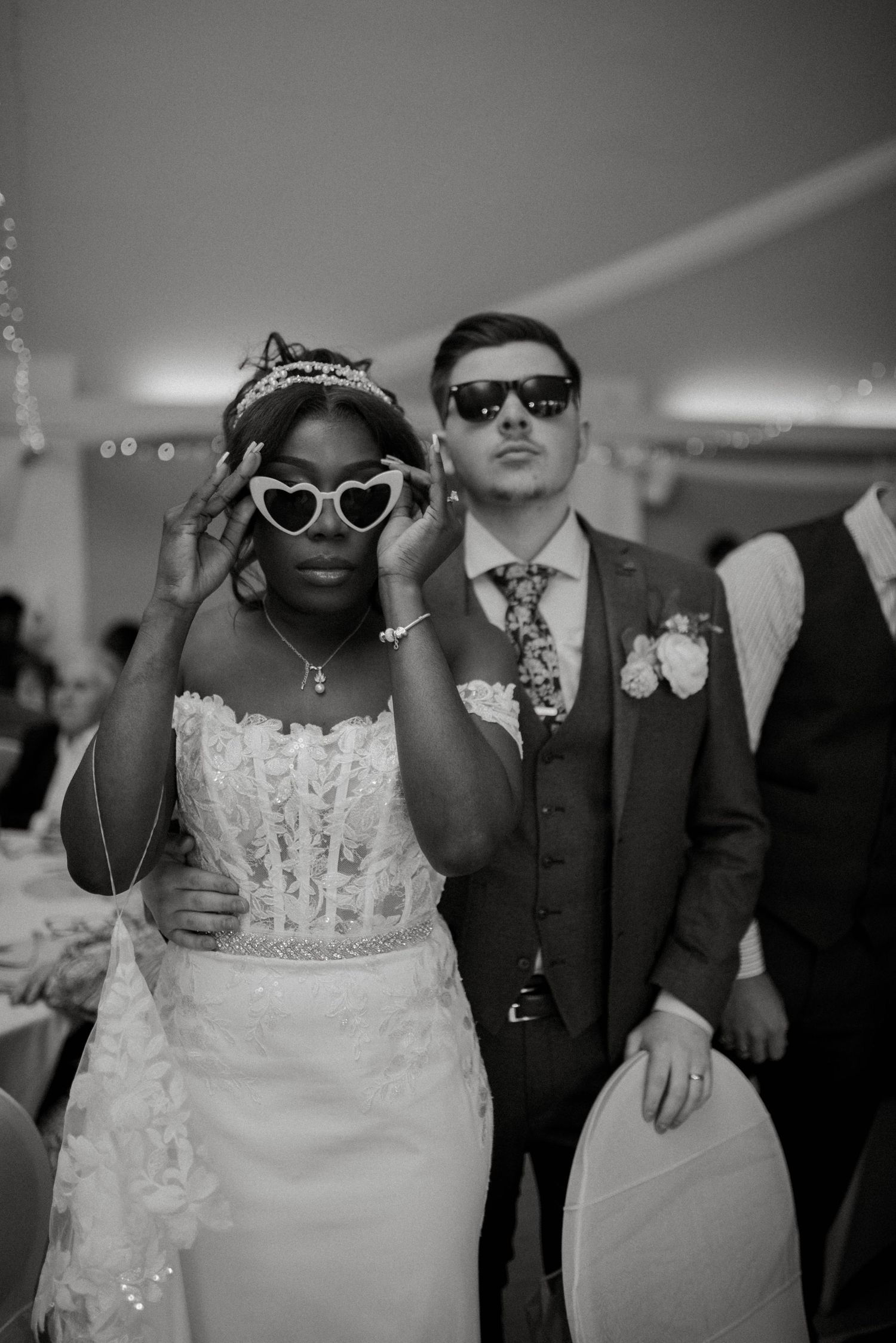 Wedding guests dance and celebrate together on a dimly lit dance floor during an evening reception.